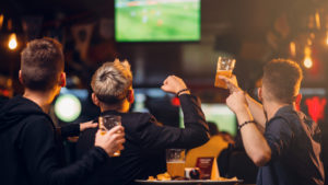 Sports fans enjoying a game at a bar showing4 Reasons an NYC Sports Bar Beats a Packed Stadium Every Time