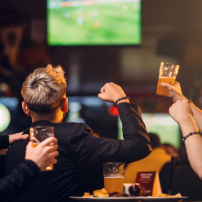 Sports fans enjoying a game at a bar showing4 Reasons an NYC Sports Bar Beats a Packed Stadium Every Time